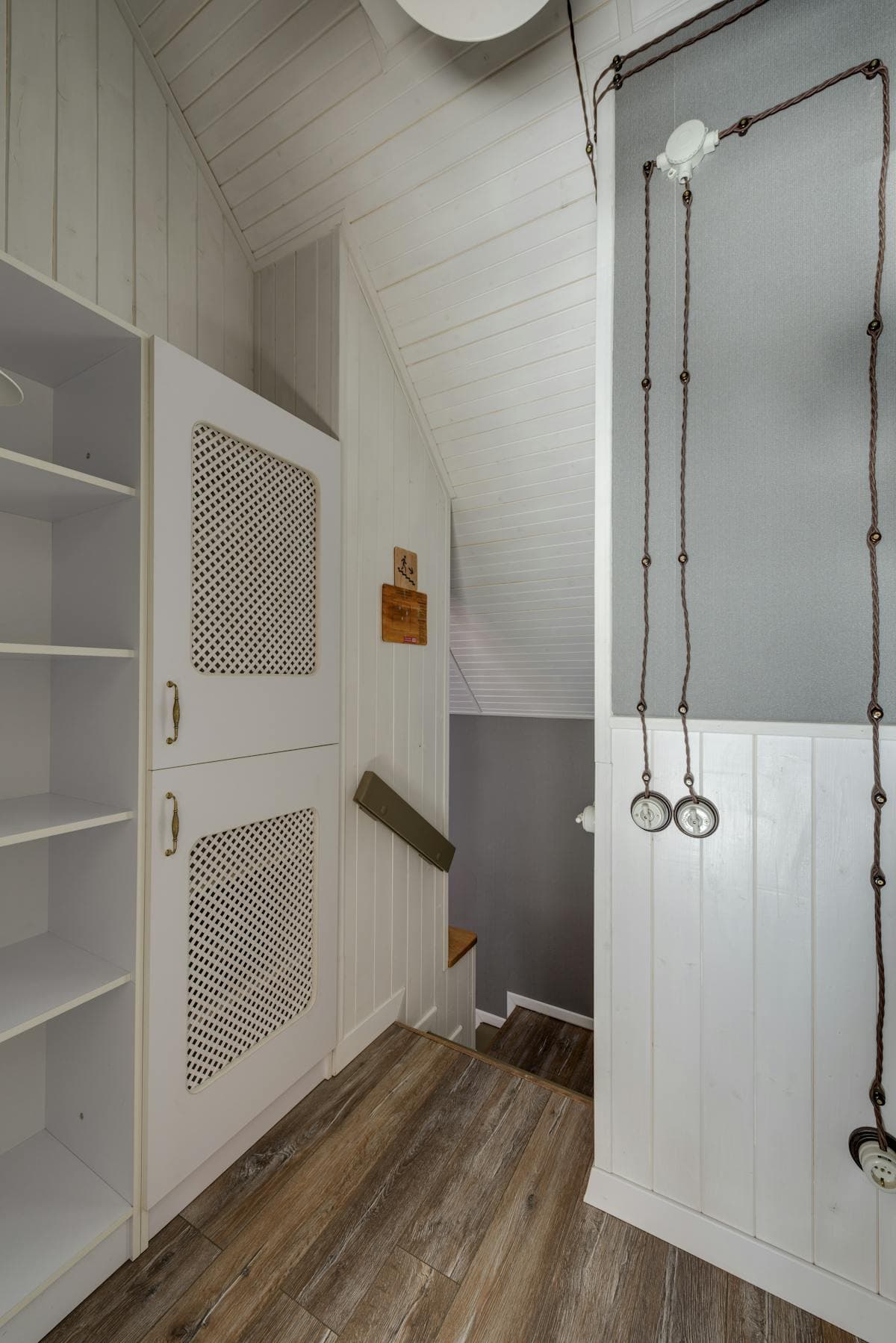Inspiration reference photo: fitted cupboards with lattice fretwork door inserts, sat against tongue-and-groove wall panelling — used as fretwork inspiration.