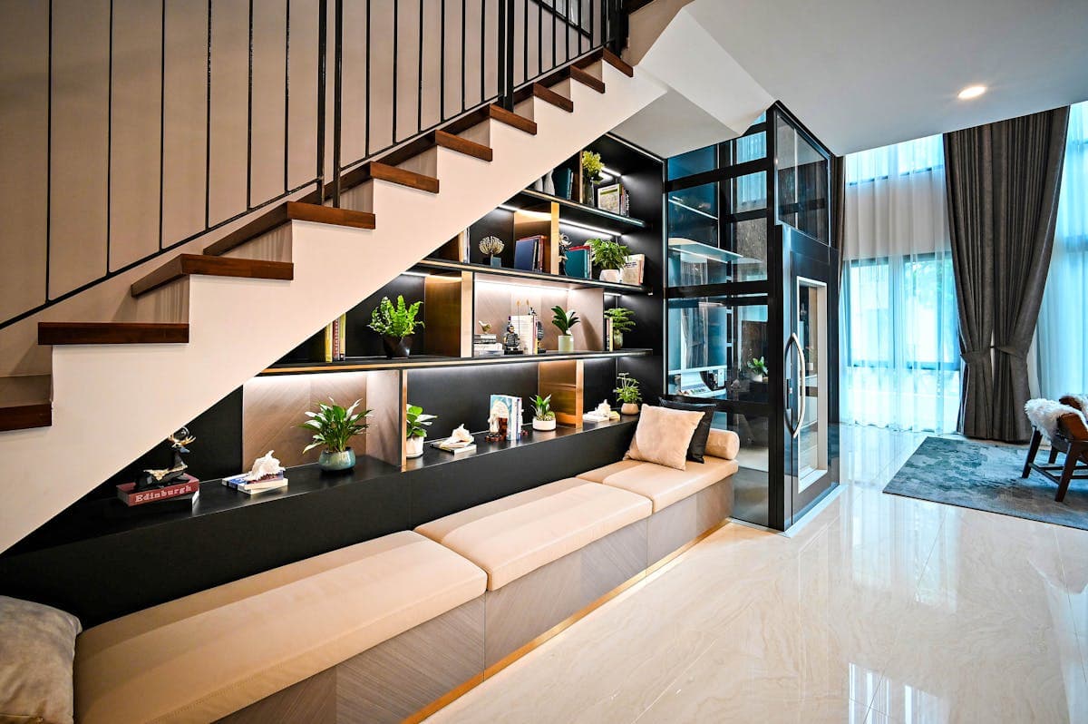 Fitted under-stairs storage with bench seating, lit shelving and tucked storage built into the stair void